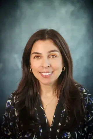 Woman with dark hair in floral print shirt