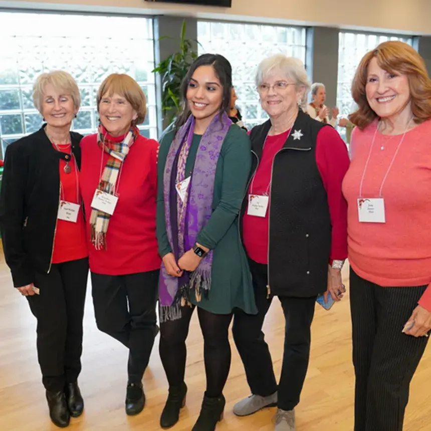 Group photo of alumni with student