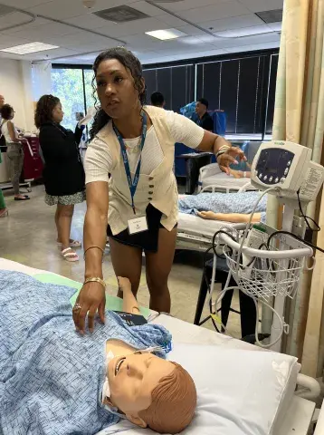 Prospective student works on a "patient" in the simulation lab