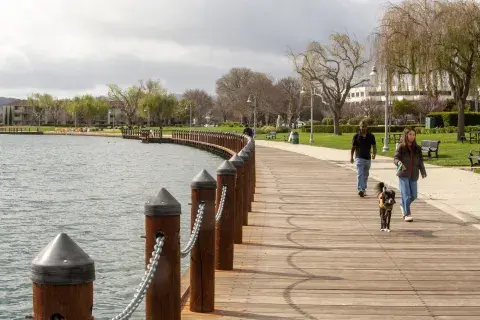 Scenic view of boardwalk around lake with people walking