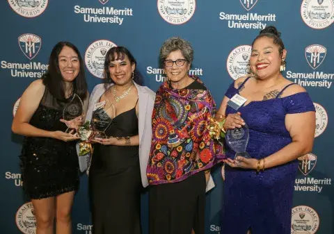 Four award recipients pose with their trophies at the Samuel Merritt University Health Impact Awards.