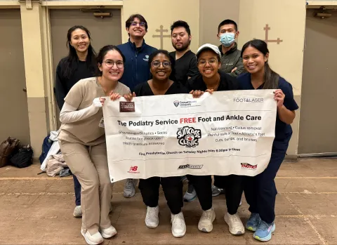 Students standing behind banner reading Suitcase Clinic
