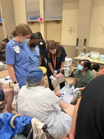 Doctor treating a patient with students surrounding and learning