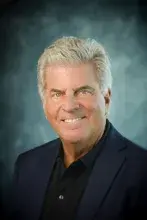 Headshot of man in dark suit