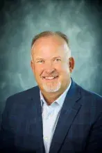 Man wearing gray suit and blue shirt