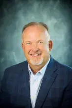 Man wearing gray suit and blue shirt