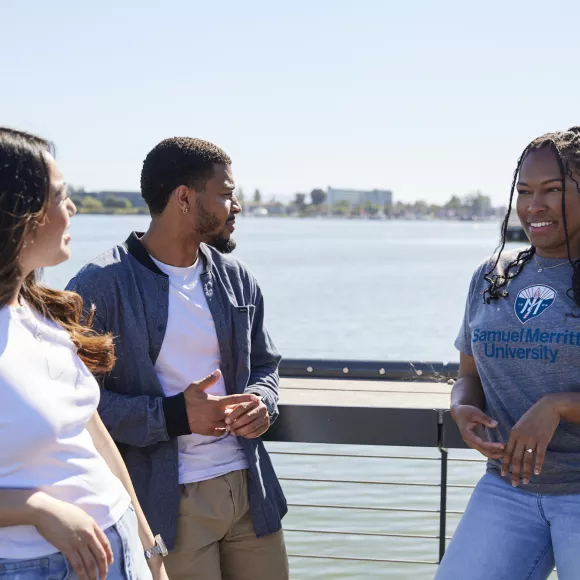 Students talking and standing near Oakland estuary