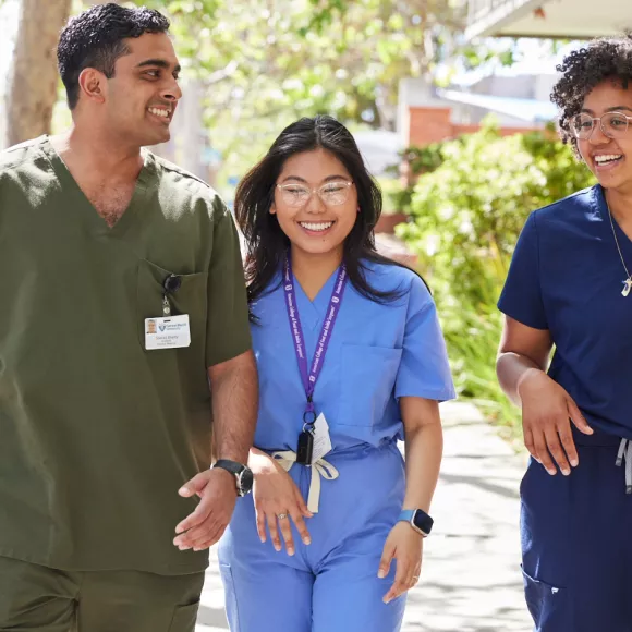 Three students in scrubs walking down the street