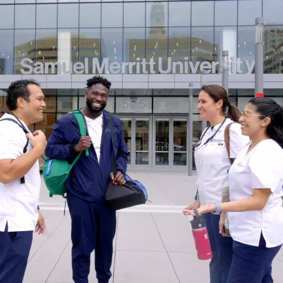 Four Samuel Merritt University nursing students talking outside the campus entrance