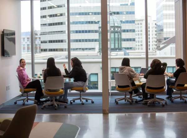 students and staff in meeting room in Oakland campus building