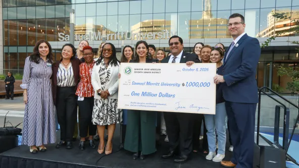Members of SMU and government officials gather on stage in front of the SMU Oakland campus to accept a $1M check from the State of California for human trafficking response program expansion.