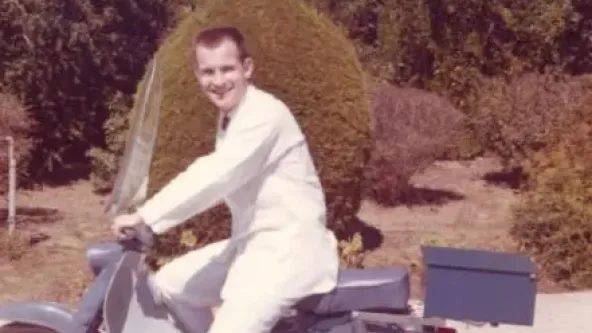 Man on motorcycle wearing a lab coat