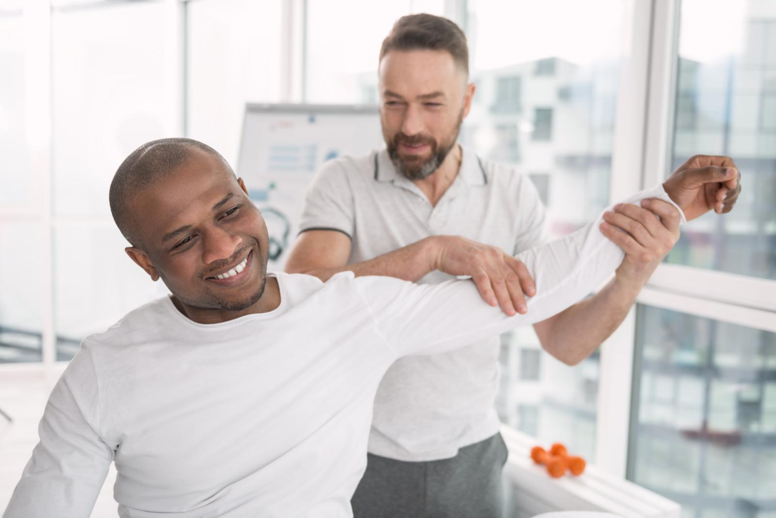 Therapist leads client with arm exercises 