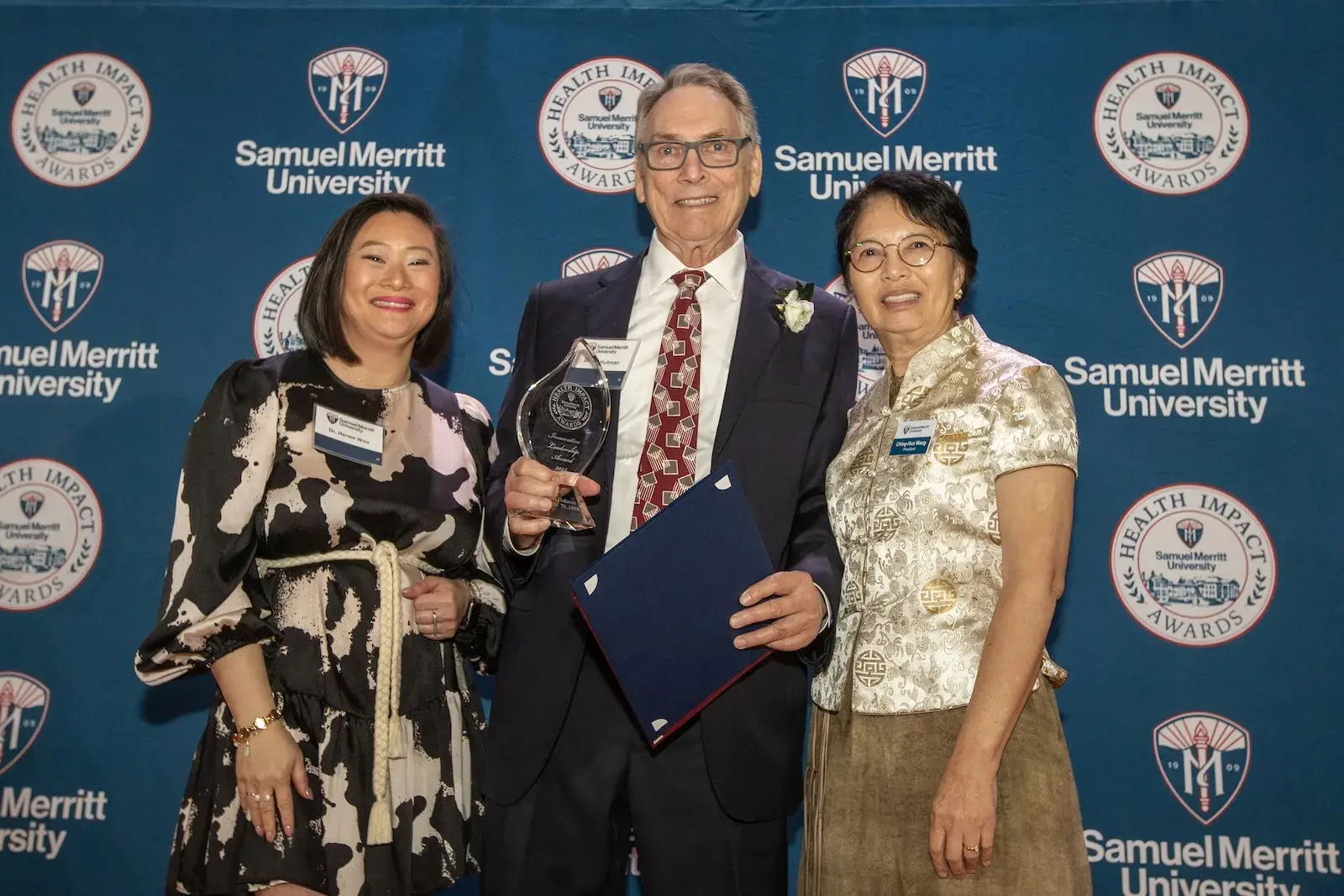 Group of three standing in front of HIA banner