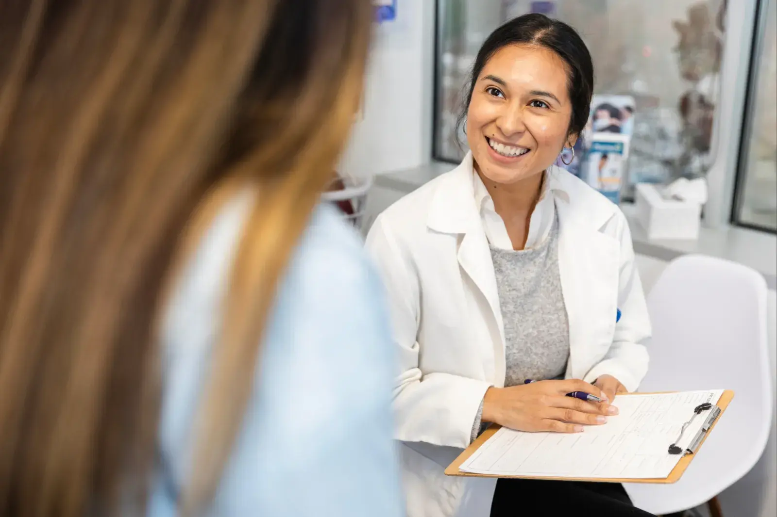 Woman in a white coat speaking with a patient