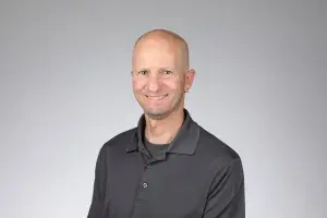 Man with gray shirt smiling at camera