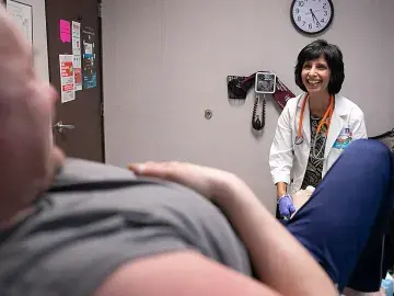 Surani Hayre-Kwan visits with a patient