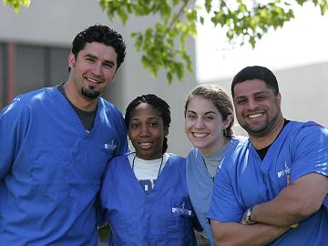 Students in blue scrubs outdoors