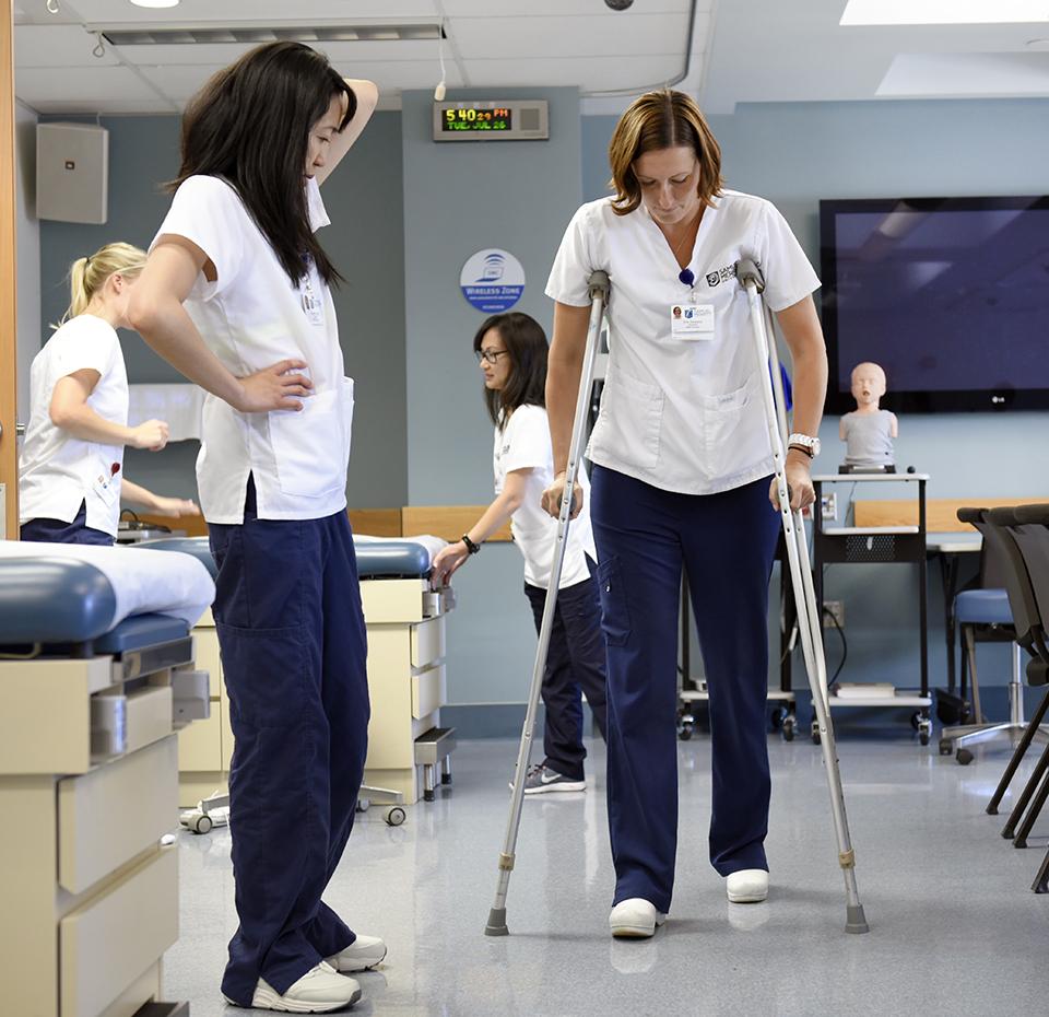 Students working with crutches in Health Sciences Simulation Center